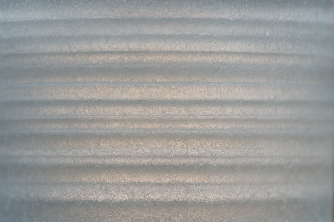Macro photograph of a translucent ice core section showing fine horizontal annual layers, backlit